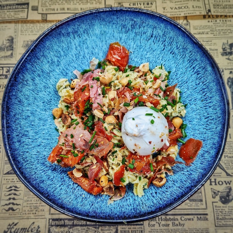 Pâtes au jambon grillé, stracciatella, crème de pesto aux herbes, noisettes, tomates confites