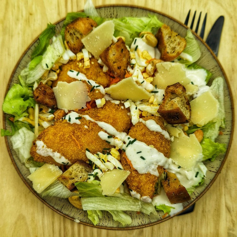 Salade César : Poulet pané, sauce Caesar, parmesan, croûtons, carottes, oeuf, noix de cajou, salade