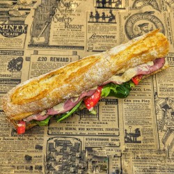Sandwich Le Manhattan : bœuf pastrami, sauce au poivre, parmesan, oignons rouges , tomate, salade.