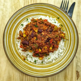 Chili con carne : boeuf haché, tomate, oignons, maïs, haricots rouges, ail servi avec du riz