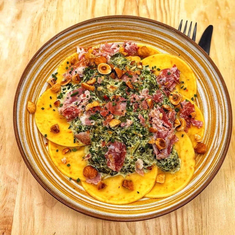 Ravioles aux aubergines et tomates confites, crémeux d'épinard, pancetta grillée et noisettes torréfiées